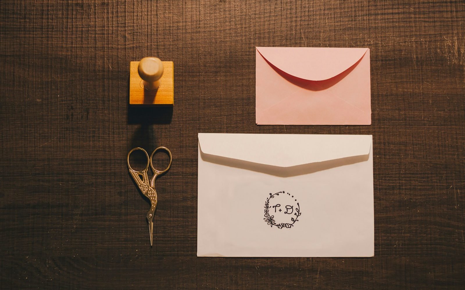 Sello de goma, tarjeta y tijeras sobre una mesa de trabajo